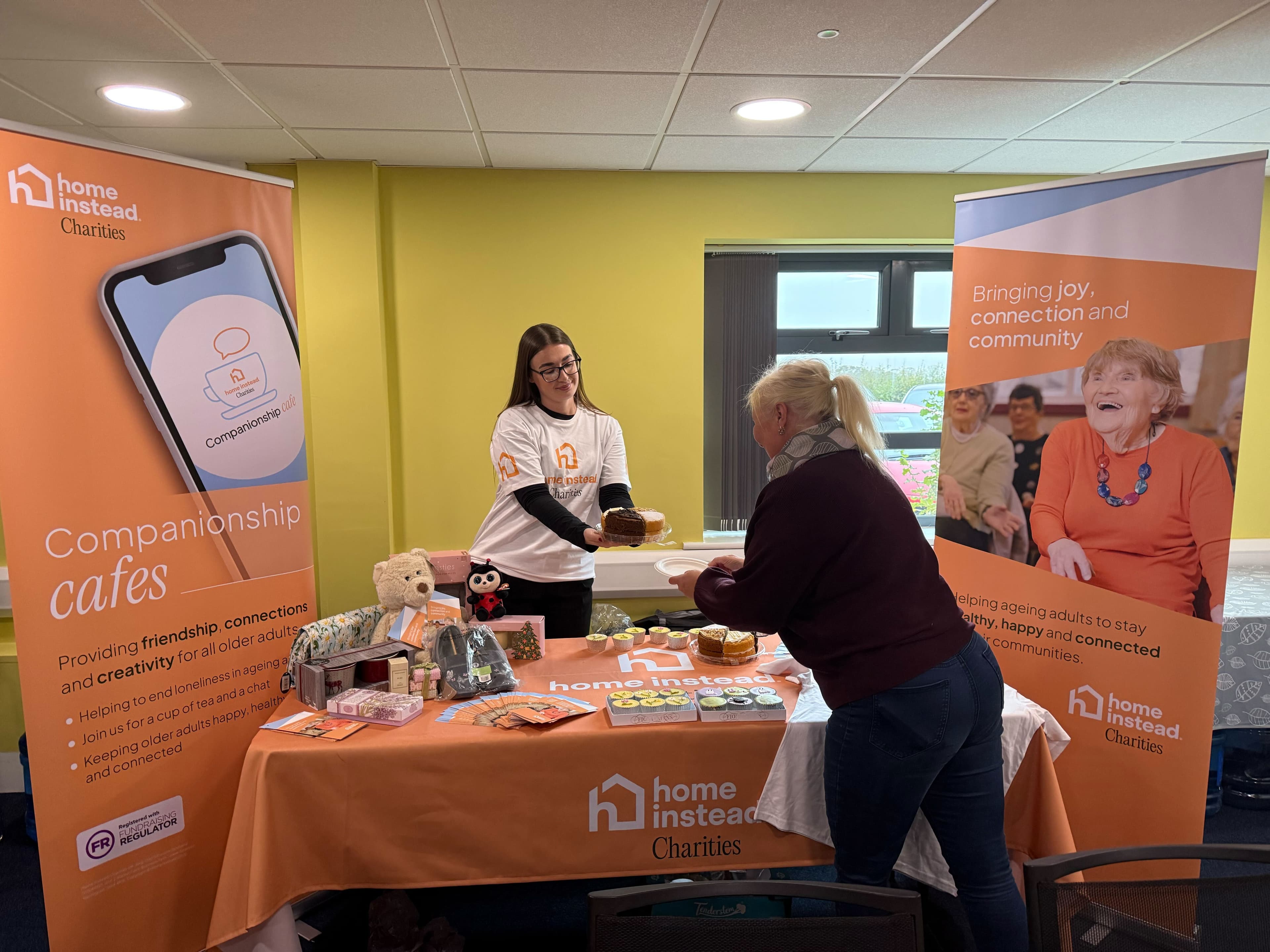 Two women at a Home Instead Charities stall