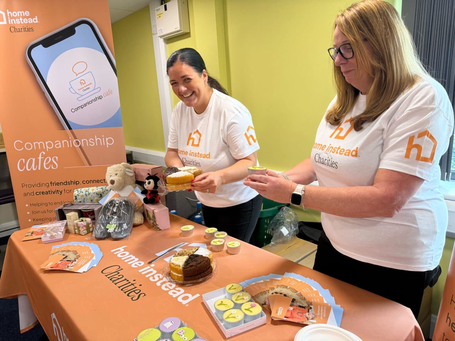 Two women at a bake stall for Home Instead charities